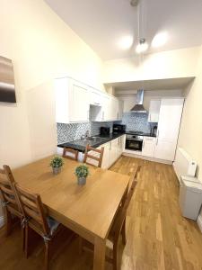 cocina con mesa de madera y sillas en Camden Budget Suites - Next to Station and Camden Market, en Londres