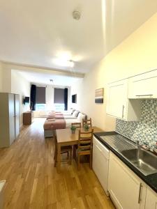 uma cozinha e sala de estar com um sofá e uma mesa em Camden Budget Suites - Next to Station and Camden Market em Londres