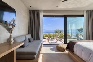 sypialnia z łóżkiem, kanapą i dużym oknem w obiekcie ​Le Grand Bleu Resort w mieście Derveni