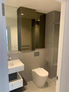 a bathroom with a toilet and a sink and a mirror at Spencer St 1bd Lvl 47 Melbourne CBD in Melbourne