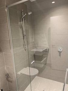 a bathroom with a shower with a toilet and a sink at Spencer St 1bd Lvl 47 Melbourne CBD in Melbourne