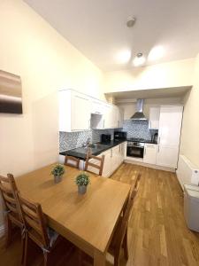 a kitchen with a wooden table in a room at Camden Budget Suites - Next to Station and Camden Market in London