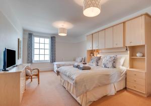 a bedroom with a large bed and a television at Bayards Cottage in Dartmouth