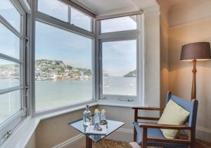 a room with a window with a view of the water at Bayards Cottage in Dartmouth