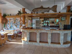 een bar in een restaurant met een vis aan de muur bij Zajazd nad stawami in Uherce Mineralne