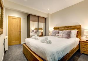 a bedroom with a large bed and a mirror at Gullsway Lower in Dartmouth