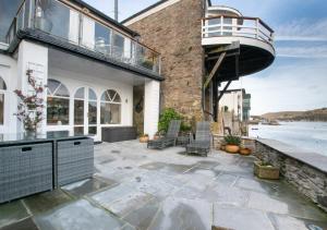 a house with a large patio with a boat on it at Gullsway Lower in Dartmouth