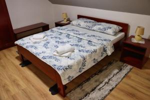 a bedroom with a bed with a blue and white comforter at Apartman Tune 