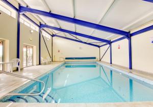 a large indoor swimming pool in a house at Bovey Cottage in Broadhempston