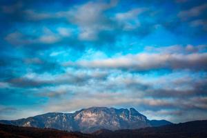 a view of a mountain with clouds in the sky at LUXURY ERK in Călimăneşti