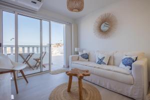a living room with a white couch and a view of the ocean at Sea Views Private Terrace 2BR House near the Beach in Telde