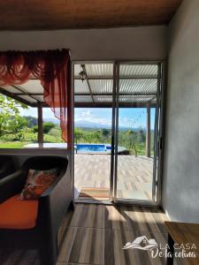 uma sala de estar com uma grande porta de vidro deslizante em Vista al Volcán Tenorio y Montaña em San Rafael