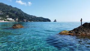 un cuerpo de agua con una cruz en el medio en Black Rocks Luxury Seafront Beach Suite, en Agios Gordios