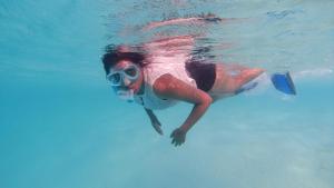 a person swimming in the water in a pool at Jerrys Dive Lodge Rasdhoo in Rasdhoo