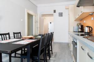 a kitchen and dining room with a black table and chairs at Spacious Apartments Zyblikiewicza Street in Krakow