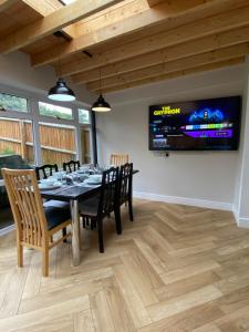 a dining room with a table and chairs and a tv at Spacious 4 Bedroom House in Northampton by HP Accommodation - Free Private Parking in Northampton