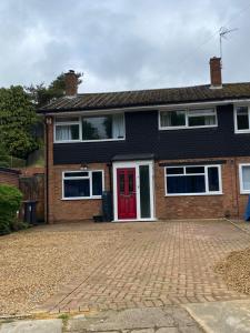 uma casa com uma porta vermelha e uma entrada de tijolos em Spacious 4 Bedroom House in Northampton by HP Accommodation - Free Private Parking em Northampton