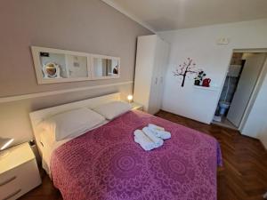 a bedroom with a purple bed with two towels on it at Guesthouse Villa Stanovic Vlaho in Cavtat