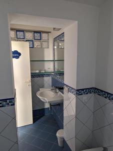 uma casa de banho azul e branca com um lavatório e um WC em Ponza Holiday Homes - Porto em Ponza