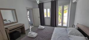 Elaion Vacation Home في ناكسوس تشورا: غرفة نوم بسرير ومرآة ومدفأة