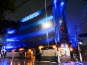 a building with blue lights on the side of it at Lina Motel Tatuapé in São Paulo