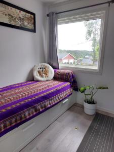 asiento junto a la ventana con un osito de peluche en una almohada en Cosy family home with pool en Grimstad