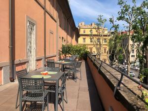 a balcony with tables and chairs on a building at Basilica Hotel in Rome