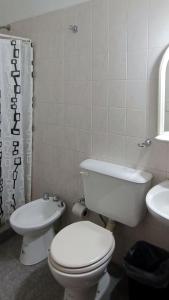 a bathroom with a toilet and a sink at Cabañas Los Pinos in Potrero de los Funes