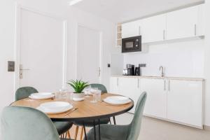 a dining room with a wooden table and chairs at Amazing Appartement - 6P2BDR - La DéfensePuteaux in Puteaux