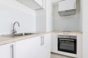 a white kitchen with a sink and a stove at Amazing Appartement - 6P2BDR - La DéfensePuteaux in Puteaux