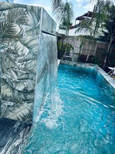 a swimming pool with a water fountain in the middle at Ilio Boutique Hotel in Ksamil