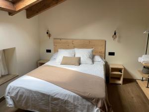 una camera con un grande letto con testiera in legno di Fábrica de Harinas La Gloria a San Millán de la Cogolla