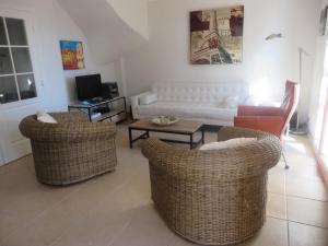 a living room with two chairs and a couch at Villa les Coralines in Les Issambres