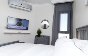ein Schlafzimmer mit einem Bett und einem TV an der Wand in der Unterkunft Porto Said Tourist Resort Luxury Hotel Apartment in Port Said