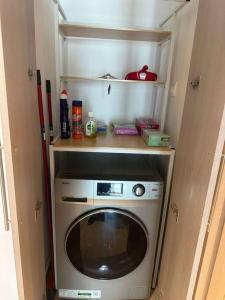 a small kitchen with a washing machine in a room at The Sea World Lookout Loft in Abu Dhabi