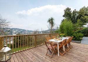 eine Holzterrasse mit einem Tisch und Stühlen darauf in der Unterkunft Vane Hill Crest in Torquay