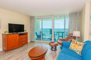 a living room with a blue couch and a television at Direct Oceanfront Condo-Sandy Beach Resort 1610- Sleeps 6! in Myrtle Beach