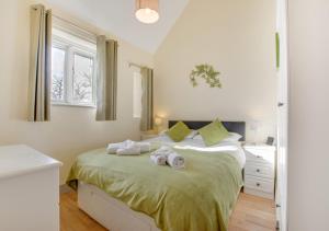 a bedroom with a bed with towels on it at Teign Cottage in Broadhempston +24 photos