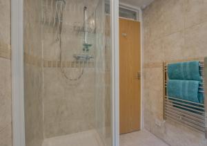 a bathroom with a shower with a blue towel at 11a Waterhead Close in Kingswear