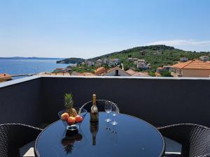 a table with a bottle of wine and fruit on a balcony at Penthouse Petra with hot tub in Kali