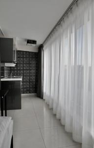 a room with white curtains and a kitchen at Super Stay Hotel, Oslo in Oslo