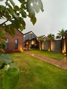 a house with a glass facade and a yard at شاليه كوتج in Buraydah