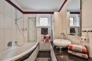 biała łazienka z wanną i umywalką w obiekcie Chalet Sofie w mieście Ischgl