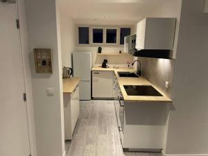 uma cozinha com electrodomésticos brancos e piso em madeira em Spacious Marina & See view appartment em Cavalaire-sur-Mer