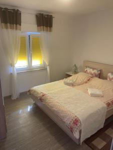 a bedroom with a bed and a window with curtains at Apartments Marija in Vir