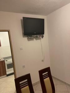 a television on the corner of a room with two chairs at Apartments Marija in Vir