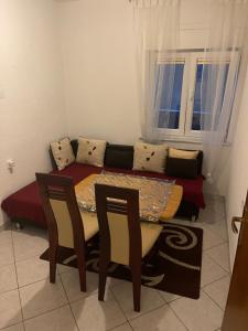 a table and chairs in a room with a couch at Apartments Marija in Vir