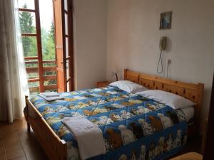 a bedroom with a bed with a quilt on it at Albergo Ristorante Pineta in Collio