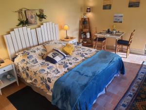 a bedroom with a large bed and a table and chairs at TY La Source in Plestin-les-Grèves