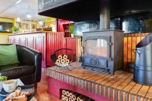 a living room with a stove and a couch at Campanile Hotel Wakefield in Wakefield